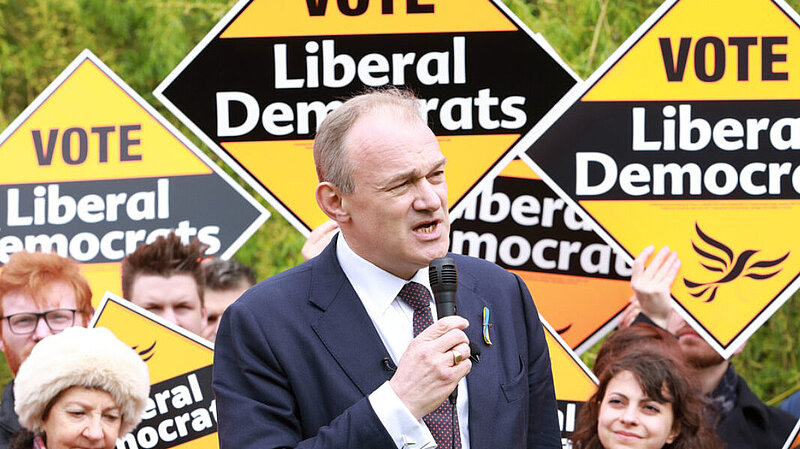 Ed Davey in front of a crowd holding Liberal Democrat posters